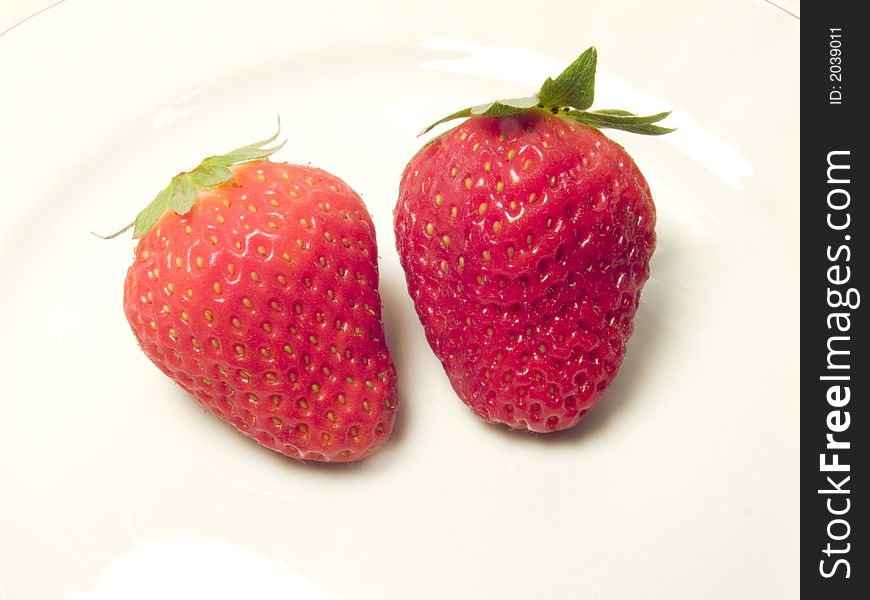 Two red strawberries as spring fruit in the meal