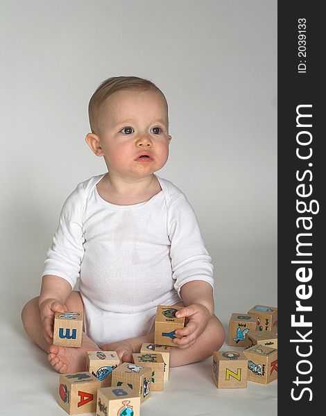 Image of cute baby playing with alphabet blocks
