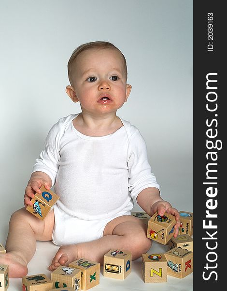 Image of cute baby playing with alphabet blocks