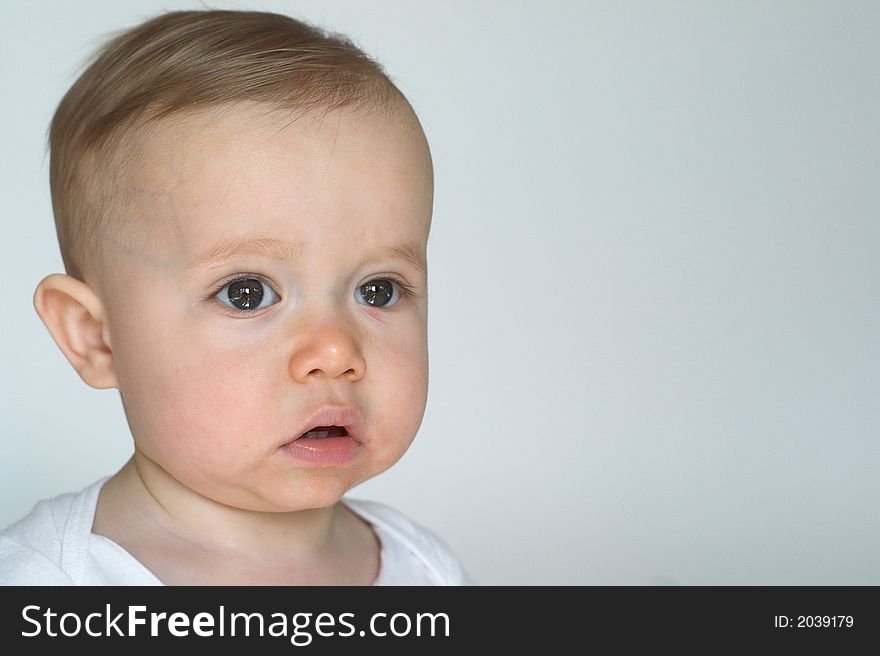 Image of beautiful 10 month old baby boy sitting in front of a white background. Image of beautiful 10 month old baby boy sitting in front of a white background