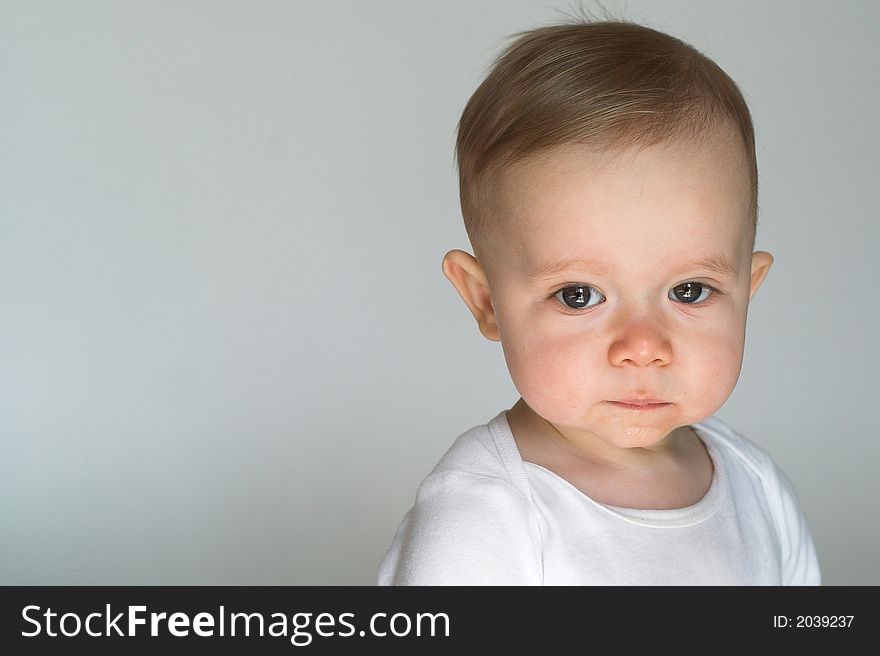Image of beautiful 10 month old baby boy sitting in front of a white background. Image of beautiful 10 month old baby boy sitting in front of a white background