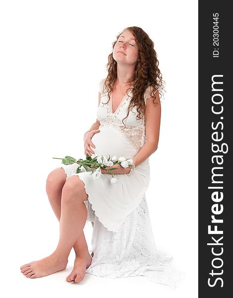 Pregnant woman caressing her belly over white background