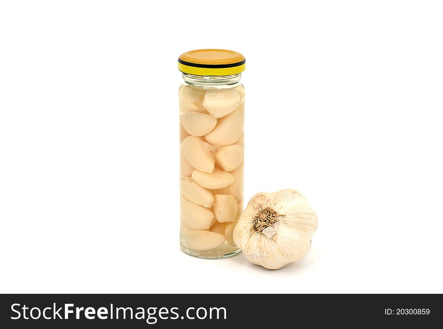 Preserved garlic in a narrow glass jar. Preserved garlic in a narrow glass jar
