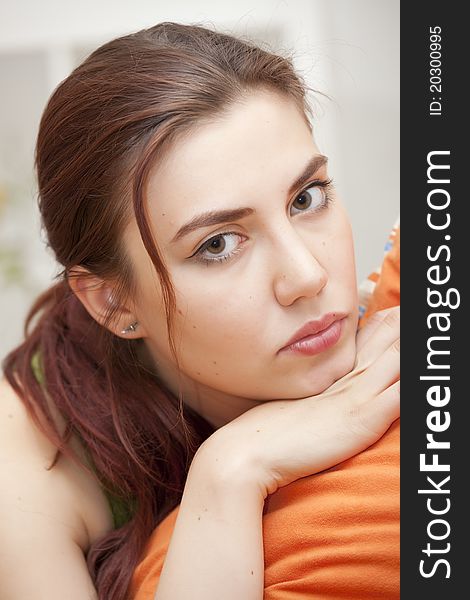 Close portrait of sad and unhappy woman with pillow