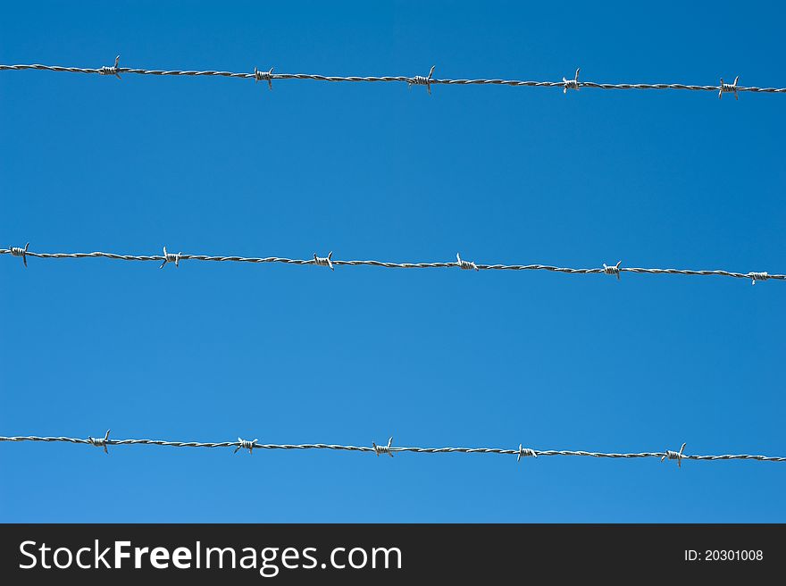 Image of a barbed wire against the blue sky