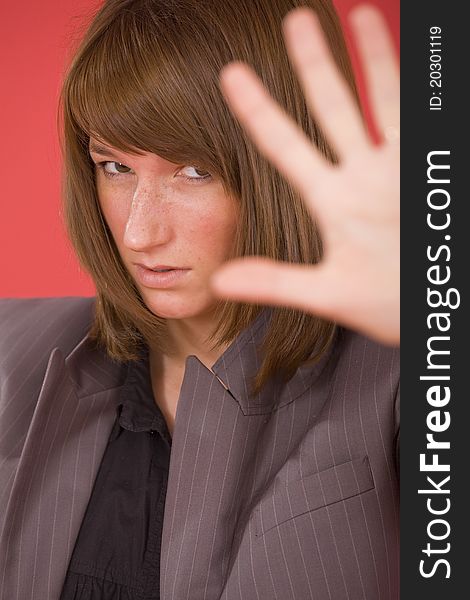 Woman in formal suit making a stop sign with hand