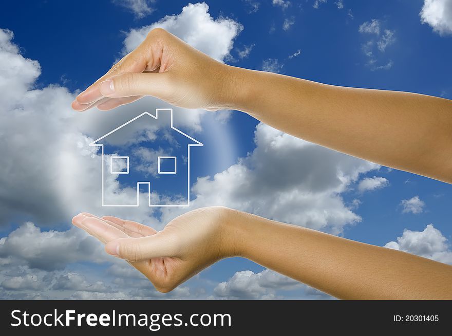 Woman hand and glowing house icon with blu sky background. Woman hand and glowing house icon with blu sky background