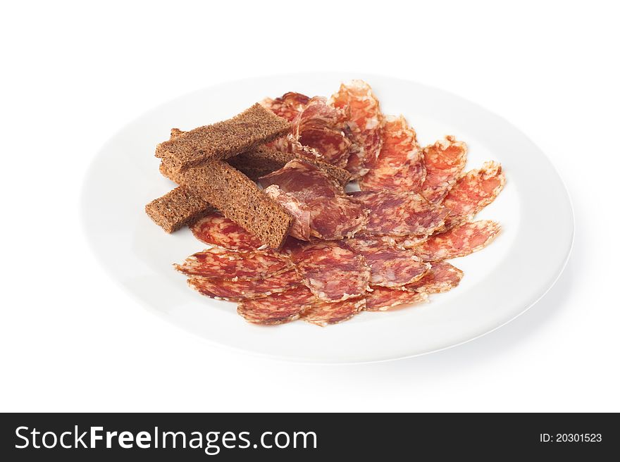 White plate with sliced salame sausage and several slices of rye-bread. White plate with sliced salame sausage and several slices of rye-bread.