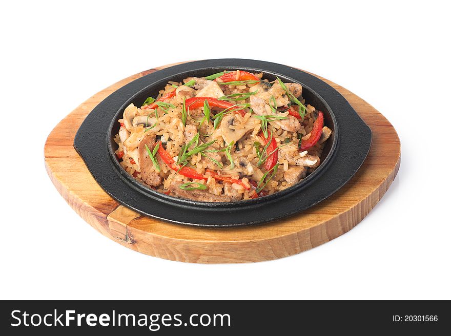 Dish of rice, braised meat and vegetables on a wooden trivet. Dish of rice, braised meat and vegetables on a wooden trivet