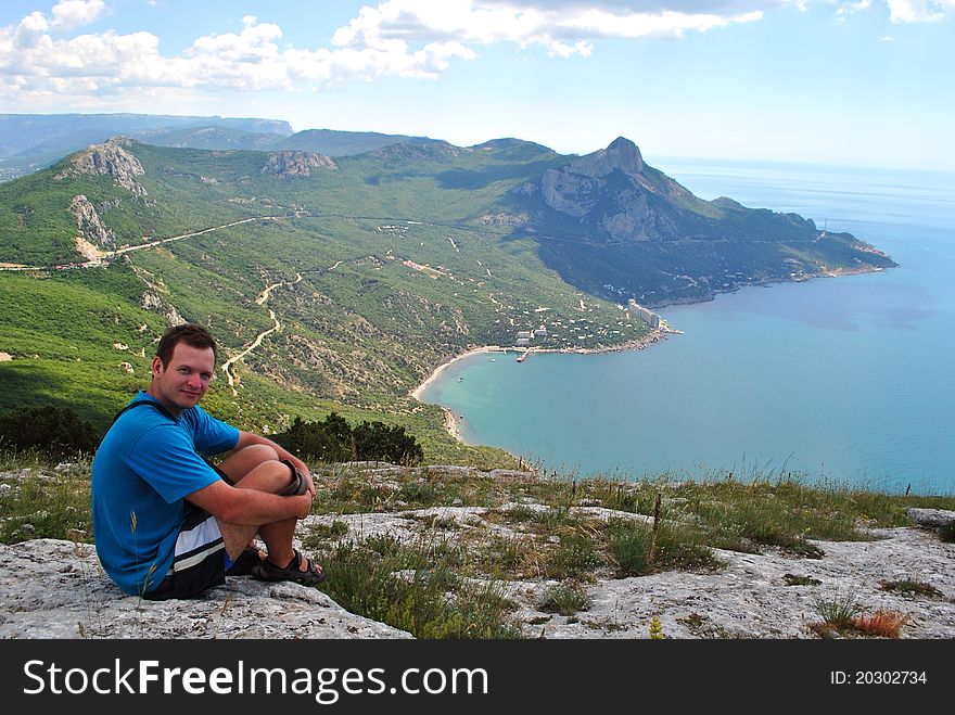 Hiker is seating near the bay. Hiker is seating near the bay