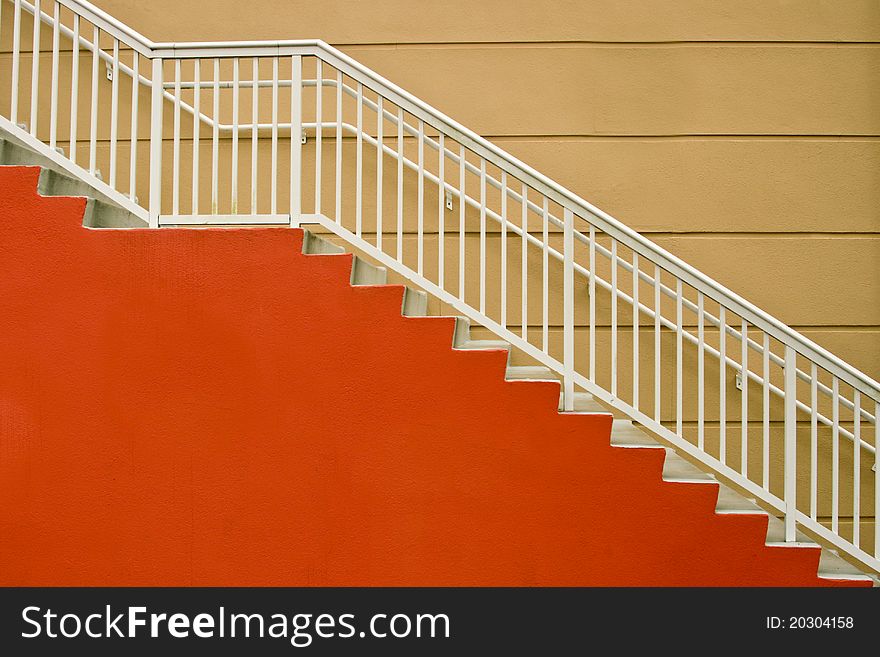 Red and white stairway against mustard- colored wall