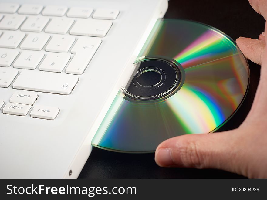 Cd in a white notebook with fingers. Cd in a white notebook with fingers