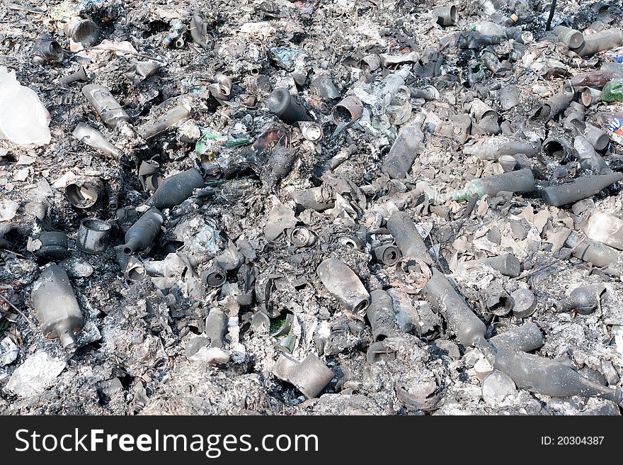 Burned cans and bottles after the burning of garbage