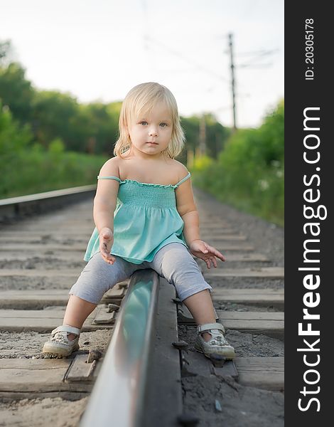 Adorable toddler girl sit on rail look to camera. Adorable toddler girl sit on rail look to camera