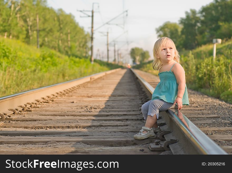 Adorable girl sit on rail wait for train