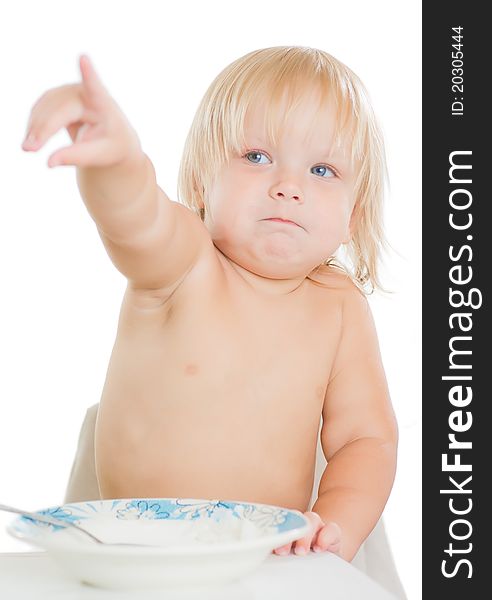 Adorable toddler girl eat porridge with spoon from plate