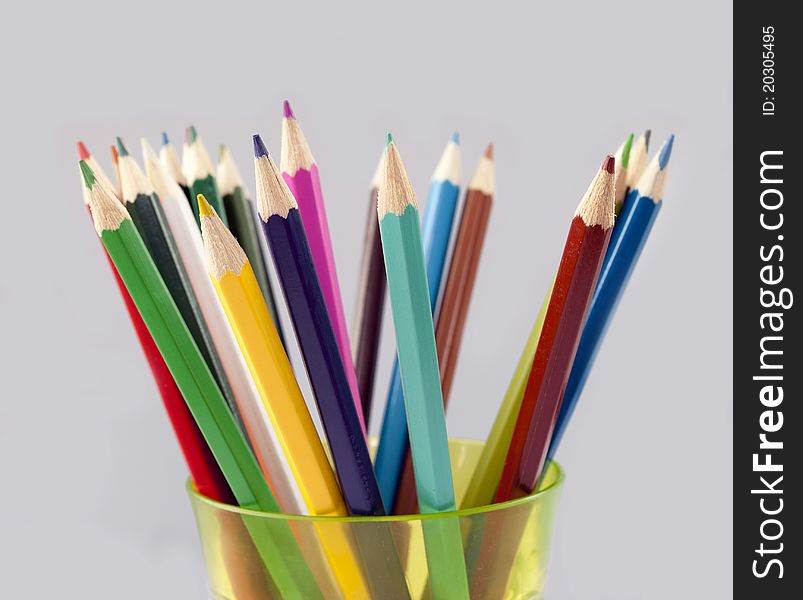 Colored pencils standing in a yellow glass