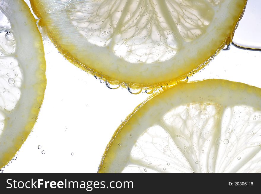Slice of lemon in the water with bubbles