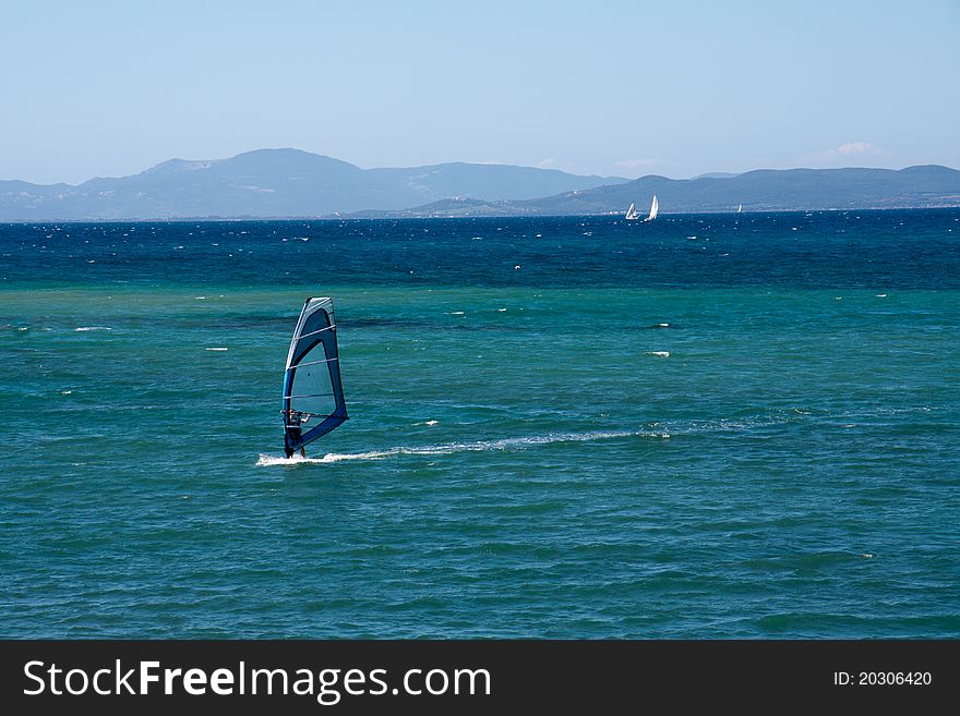 Windsurf heading to left with sailign boats in the backgrounds. Windsurf heading to left with sailign boats in the backgrounds