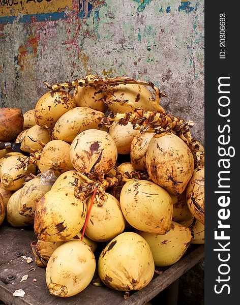 Bunch of yellow coconuts against a wall. Bunch of yellow coconuts against a wall