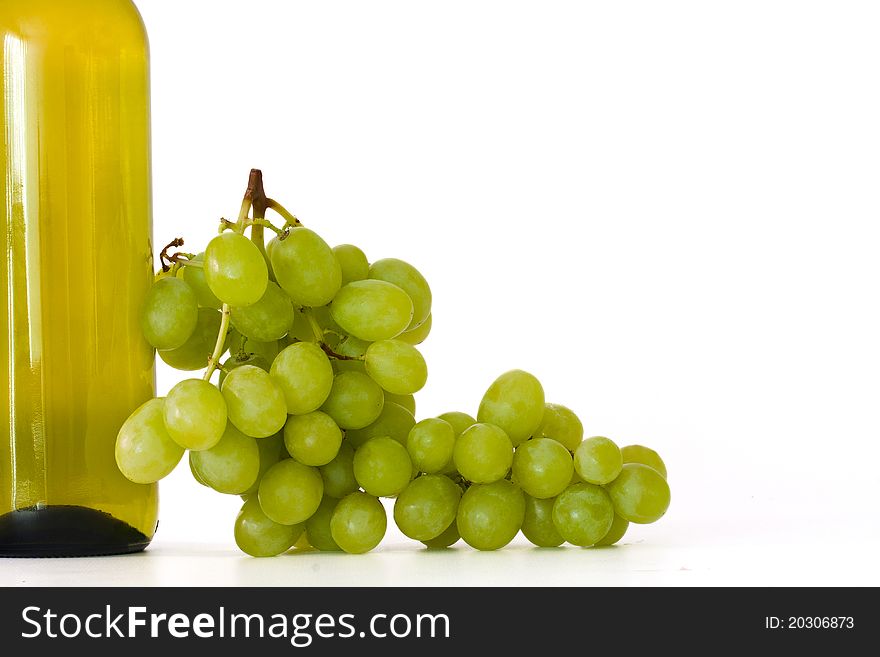Bottle of wine with grapes isolated on white background
