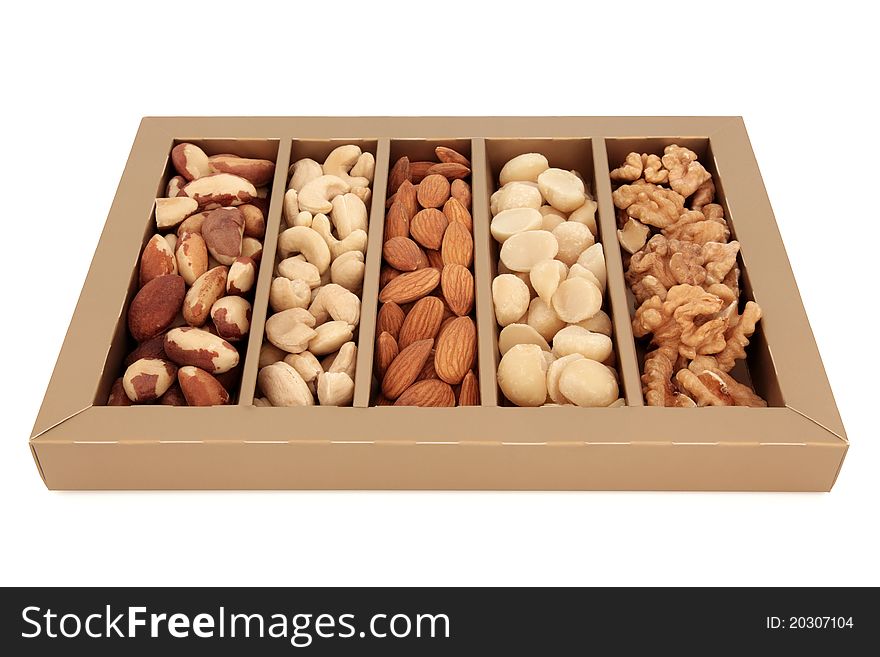 Nut selection of brazil, cashew, almond, macadamia and walnut in a gold display box isolated over white background.