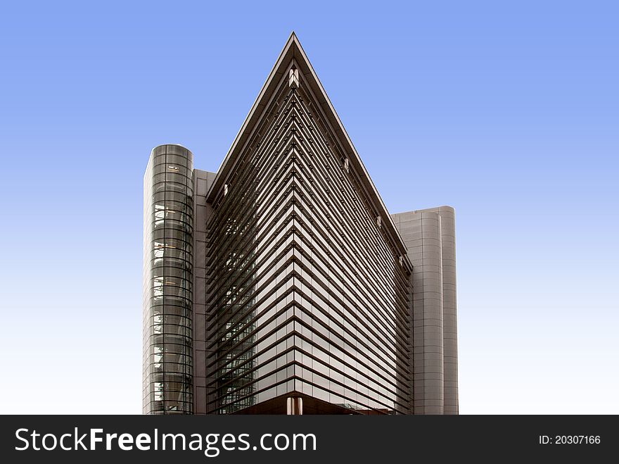 A Glass Office Block shaped like an ocean liners bows against a blue sky with reflections. A Glass Office Block shaped like an ocean liners bows against a blue sky with reflections