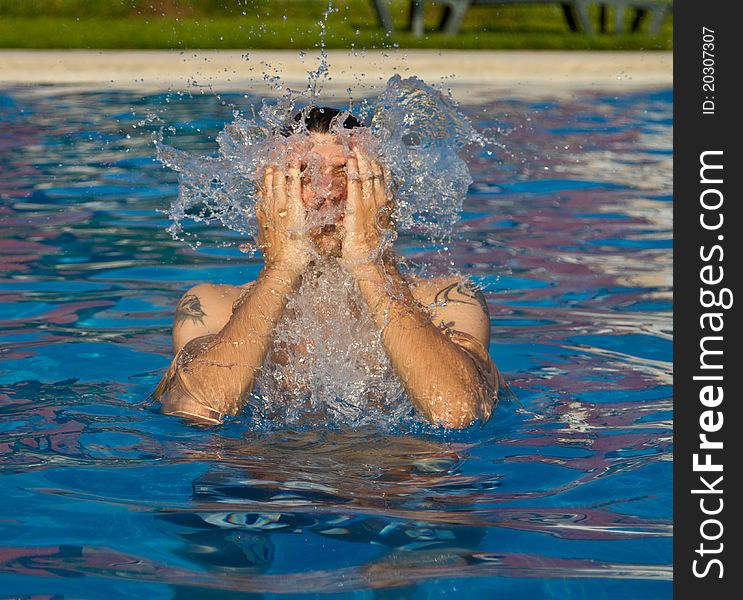Man swimming in the pool with water splashing