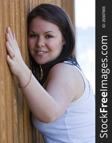 A beautiful young female leans against a wall. A beautiful young female leans against a wall