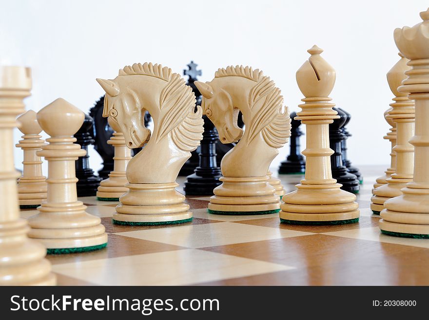 Chess pieces on wood board, black and white