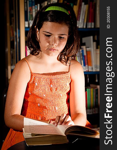 A little girl reading in a library, completely absorbed in her book. A little girl reading in a library, completely absorbed in her book.