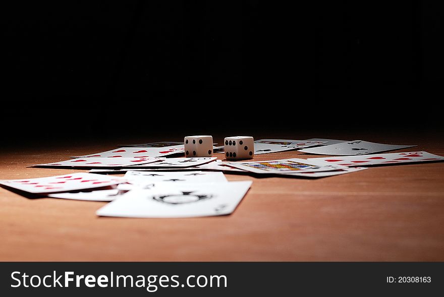 Dices on the table full of playing cards