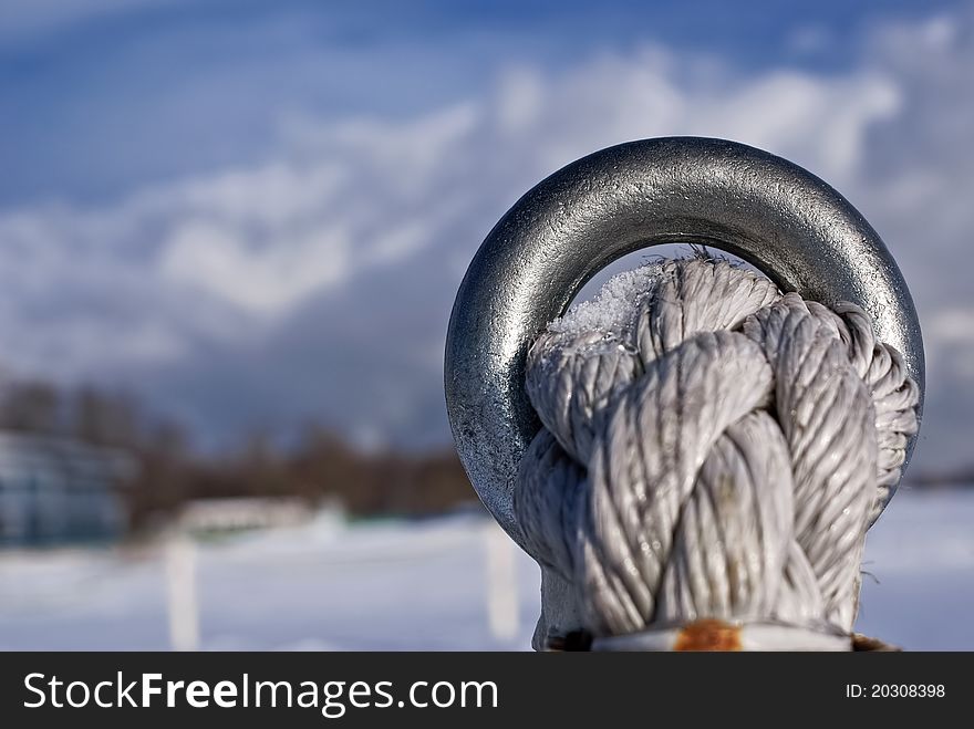 Steel gray ring with strong white rope. Steel gray ring with strong white rope