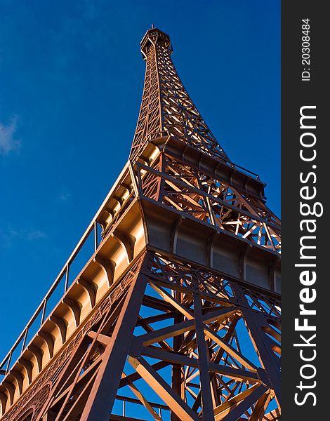 Upside view to fake Eiffel tower under blue sky