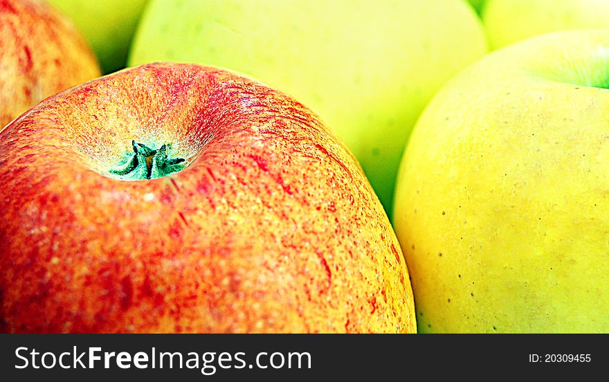 Red apple standing in front of large group of green apples. Red apple standing in front of large group of green apples