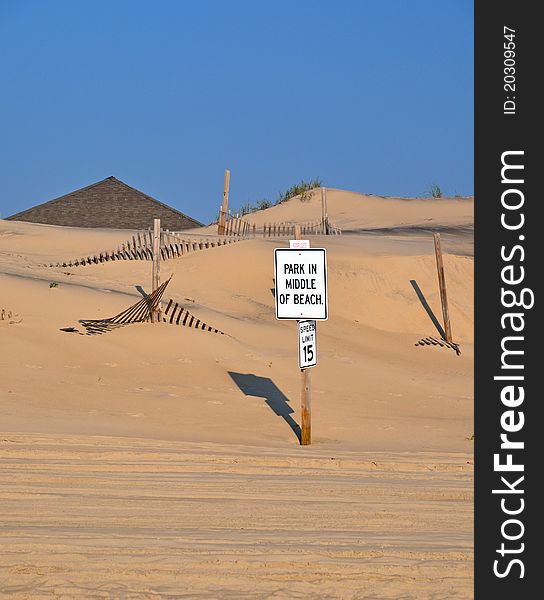 Sign encouraging beach patrons to park in the middle of the beach. Sign encouraging beach patrons to park in the middle of the beach