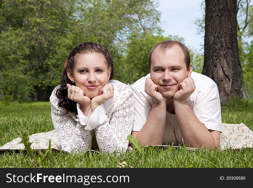Couple lays together on a grass