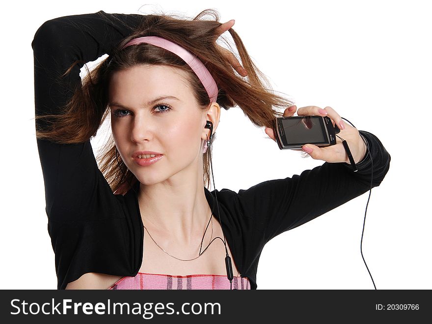 The girl with a cellular telephone listens to music in ear-phone