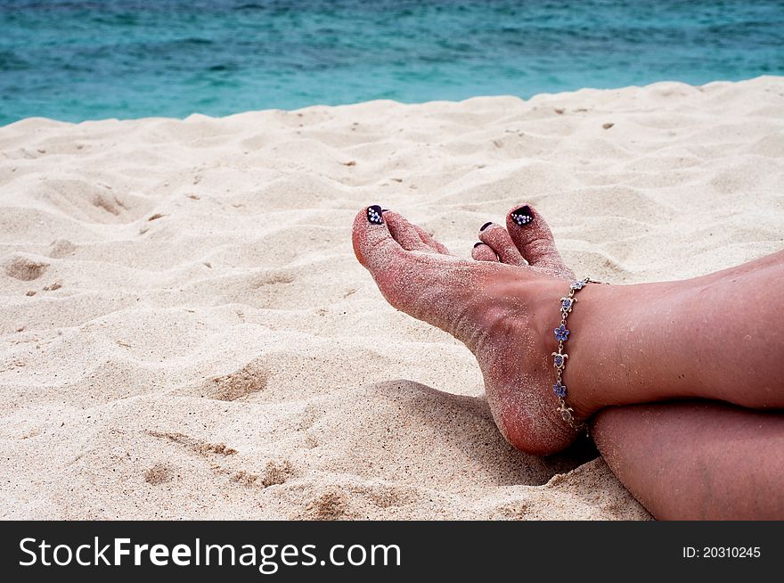 A womans sandy feet on the beach. A womans sandy feet on the beach