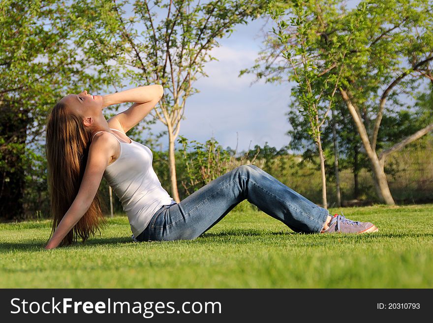 Girl sitting on the lawn and talking on the phone. Girl sitting on the lawn and talking on the phone