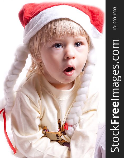Little girl in a Christmas hat with braids on a white background
