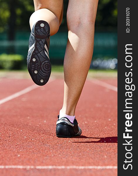 Young woman in sprinting position on the track