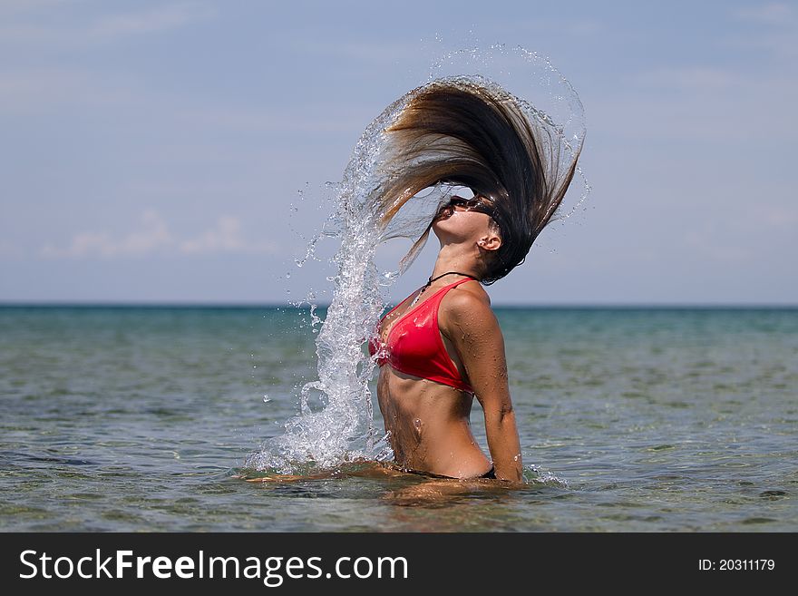 Girl splashing water with long hair