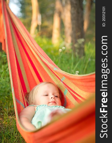 Adorable baby girl relaxing in hammock