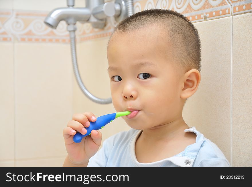 A chinese boy is brushing his teeth in bathroom. A chinese boy is brushing his teeth in bathroom