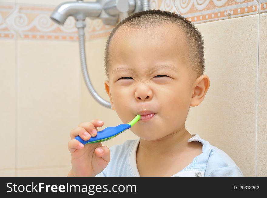 A chinese boy is brushing his teeth in bathroom. A chinese boy is brushing his teeth in bathroom