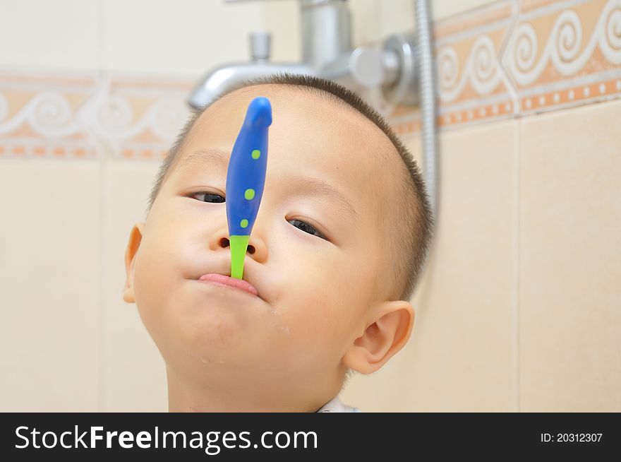 A chinese boy is brushing his teeth in bathroom. A chinese boy is brushing his teeth in bathroom