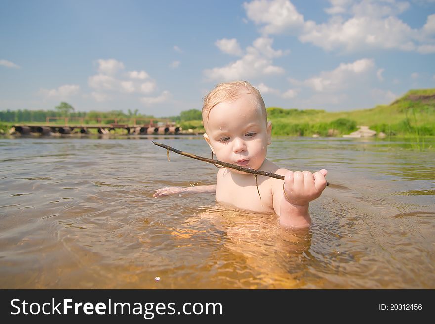 Adorable Baby Sit In River And Play With Wood