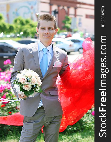 The groom with a bouquet of roses. The groom with a bouquet of roses