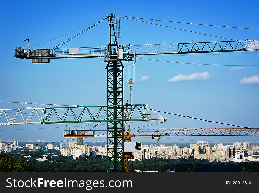 Construction site with tall cranes on background of residential and office buildings